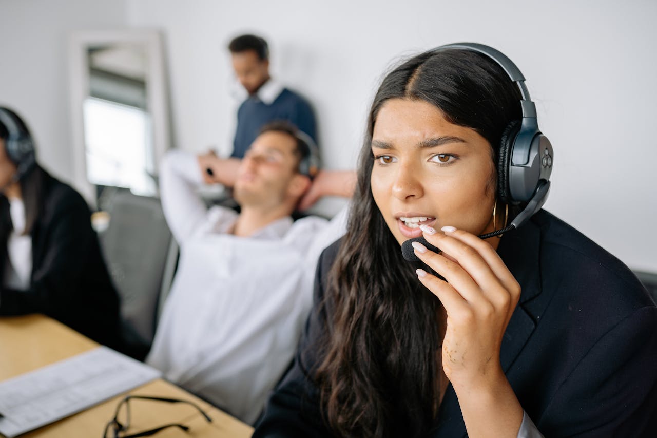 our-services-2 Close-up of a woman working in a call center, wearing a headset, focused on her task.